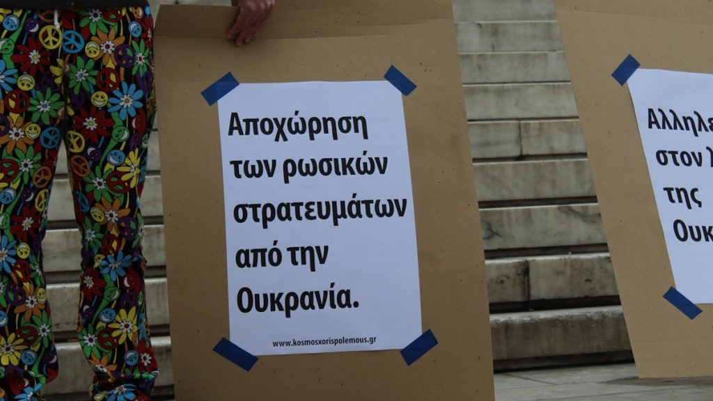 a couple of people standing next to each other holding signs