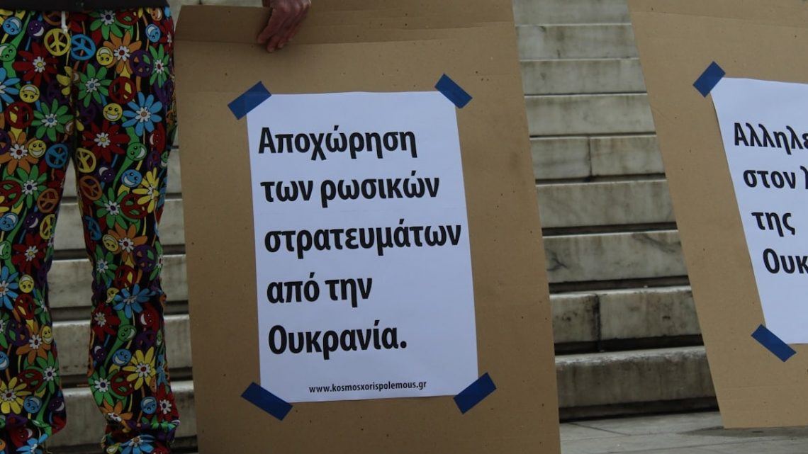 a couple of people standing next to each other holding signs